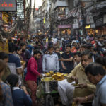 
              People eat street food as shoppers crowd a market in New Delhi, India, Saturday, Nov. 12, 2022. The world's population is projected to hit an estimated 8 billion people on Tuesday, Nov. 15, according to a United Nations projection. (AP Photo/Altaf Qadri)
            