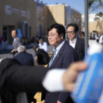 
              Akihiro Nishimura, center, minister of the environment of Japan, walks through the COP27 U.N. Climate Summit venue, Friday, Nov. 18, 2022, in Sharm el-Sheikh, Egypt. (AP Photo/Peter Dejong)
            