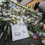 
              FILE - A woman places a flower to pay tribute to victims of a deadly accident following Saturday night's Halloween festivities on the street near the scene in Seoul, South Korea, Tuesday, Nov. 1, 2022. More than 400 people died in October in a series of crowd-related disasters in Asia that could have been prevented if authorities had acted differently. (AP Photo/Ahn Young-joon, File)
            