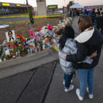 People gather around a memorial Sunday, Nov. 20, 2022, for the victims of Saturday's fatal shooting at Club Q in Colorado Springs, Colo. (Christian Murdock/The Gazette via AP)
