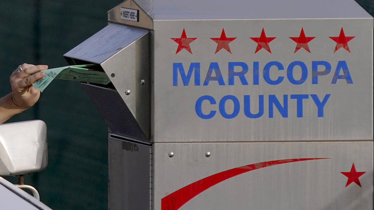 A voter casts their ballot at a secure ballot drop box at the Maricopa County Tabulation and Electi...