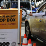 
              A driver slides a ballot into a voting drop box location, Tuesday, Nov. 8, 2022, in Honolulu. (AP Photo/Marco Garcia)
            