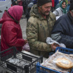 
              People receive food at a humanitarian aid point in the village of Drobysheve, Donetsk region, Ukraine, Friday, Nov. 18, 2022. (AP Photo/Andriy Andriyenko)
            