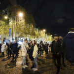 
              FILE - Spectators gather to attend the Champs Elysee Avenue illumination ceremony for the Christmas season, in Paris, Nov. 20, 2022. In cities across Europe, officials are wrestling with a choice this Christmas. Dim lighting plans to send a message of energy conservation and solidarity with citizens squeezed by both higher energy costs and inflation or let the lights blaze in a message of defiance after two years of pandemic-suppressed Christmas seasons, creating a mood that retailers hope loosen holiday purses. (AP Photo/Lewis Joly, File)
            