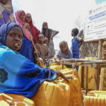 
              Isha Kerow, left, and other Somalis displaced by drought fill jerrycans with water distributed by the Norwegian Refugee Council, on the outskirts of Baidoa, in Somalia Saturday, Oct. 29, 2022. Ships loaded with grain departed Ukraine on Tuesday, Nov. 1, 2022 despite Russia suspending its participation in a U.N.-brokered deal that ensures safe wartime passage of critical food supplies meant for parts of the world struggling with hunger such as Somalia. (AP Photo/Mohamed Sheikh Nor)
            