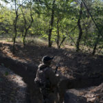 
              FILE - A Ukrainian serviceman checks the trenches dug by Russian soldiers in a retaken area in Kherson region, Ukraine, Oct. 12, 2022. Russia relinquished its final foothold in a major city in southern Ukraine on Friday Nov. 11, 2022, clearing the way for victorious Ukrainian forces to reclaim the country’s only Russian-held provincial capital that could act as a springboard for further advances into occupied territory. (AP Photo/Leo Correa, File)
            