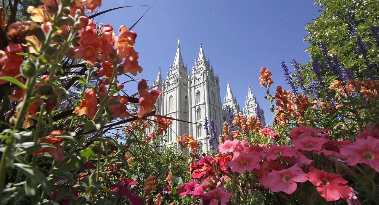 FILE - Flowers bloom in front of the Salt Lake Temple, at Temple Square, on Aug. 4, 2015, in Salt L...