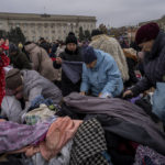
              Residents search among clothes donations at a distribution point in downtown Kherson, southern Ukraine, Friday, Nov. 18, 2022. (AP Photo/Bernat Armangue)
            