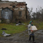 
              A woman carries a box with food after receiving it at a humanitarian aid point in the village of Drobysheve, Donetsk region, Ukraine, Friday, Nov. 18, 2022. (AP Photo/Andriy Andriyenko)
            