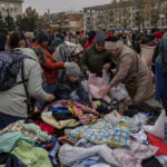 
              Residents search among clothes donations at a distribution point in downtown Kherson, southern Ukraine, Friday, Nov. 18, 2022. (AP Photo/Bernat Armangue)
            