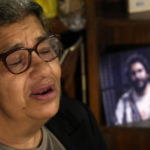
              Laila Soueif, mother of jailed pro-democracy activist Alaa Abdel-Fattah, who this week escalated a food and water strike demanding his release, speaks during an interview with the Associated Press in front of his picture at her home in Cairo, Egypt, Thursday, Nov. 10, 2022. Abdel-Fattah, who has been in prison for most of the past decade, is serving a five-year sentence on charges of disseminating false news for retweeting a report in 2019 that another prisoner died in custody. (AP Photo/Amr Nabil)
            