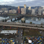
              FILE - In this aerial photo taken with a drone, tents housing people experiencing homelessness are set up on a vacant parking lot in Portland, Ore., on Dec. 8, 2020. Voters in Portland, Ore., have approved a ballot measure that would completely overhaul City Hall, amid growing public frustrations over homelessness and crime. The measure will scrap the city's unusual commission form of government and replace it with a more traditional city council. (AP Photo/Craig Mitchelldyer, File)
            