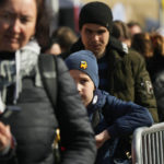 
              FILE - Refugees wait for transport after fleeing the war from neighbouring Ukraine at the border crossing in Medyka, southeastern Poland, on Saturday, March 26, 2022. Since the invasion of Ukraine more than eight months ago, Poland has aided the neighboring country and millions of its refugees — both to ease their suffering and to help guard against the war spilling into the rest of Europe. But a missile strike that killed two men Tuesday, Nov. 15 in a Polish village close to the Ukrainian border brought the conflict home and added to the long-suppressed sense of vulnerability in a country where the ravages of World War II are well remembered. (AP Photo/Sergei Grits, File)
            