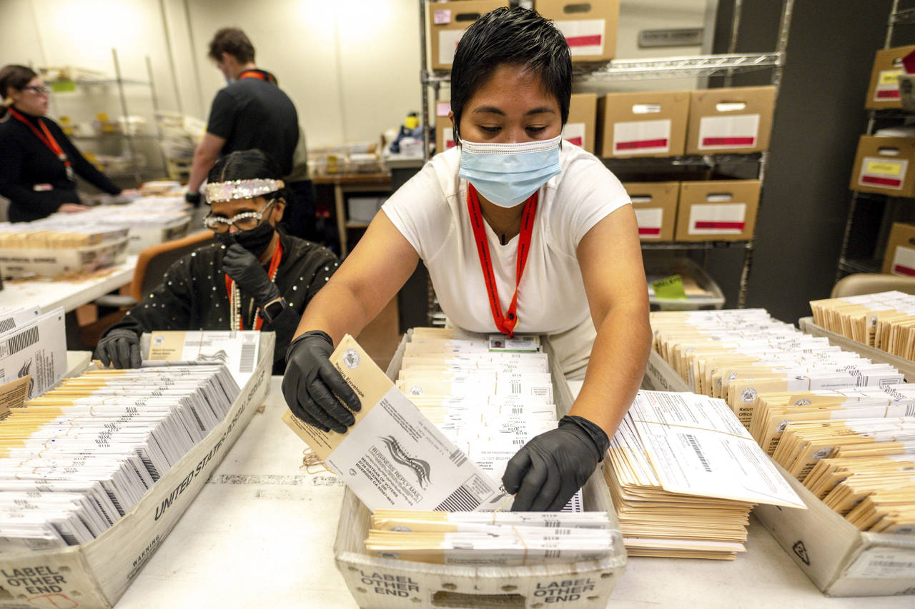 An election worker processes mail-in-ballots for the midterm election at the Riverside County Regis...