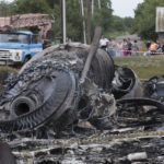 
              FILE - Local citizens, background, look at the site of a crashed Malaysia Airlines passenger plane near the village of Rozsypne, Ukraine, eastern Ukraine on July 18, 2014. A Dutch court on Thursday is set to deliver verdicts in the long-running trial of three Russians and a Ukrainian rebel for their alleged roles in the shooting down of Malaysia Airlines flight MH17 over conflict-torn eastern Ukraine. (AP Photo/Dmitry Lovetsky, File)
            
