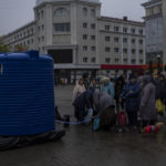 
              Residents queue to fill containers with drinking water delivered by World Central Kitchen in Kherson, southern Ukraine, Sunday, Nov. 20, 2022. Russian forces fired tank shells, rockets and other artillery on the city of Kherson, which was recently liberated from Ukrainian forces. (AP Photo/Bernat Armangue)
            