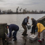 
              Residents of the recently liberated city of Kherson collect water from the Dnipro river bank, near the frontline, southern Ukraine, Monday, Nov. 21, 2022. (AP Photo/Bernat Armangue)
            