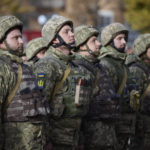 
              In this photo provided by the Ukrainian Presidential Press Office and posted on Facebook, Ukrainian soldiers line up on a central square during President Volodymyr Zelenskyy's visit to Kherson, Ukraine, Monday, Nov. 14, 2022. Ukraine's retaking of Kherson was a significant setback for the Kremlin and it came some six weeks after Russian President Vladimir Putin annexed the Kherson region and three other provinces in southern and eastern Ukraine — in breach of international law — and declared them Russian territory. (Ukrainian Presidential Press Office via AP)
            