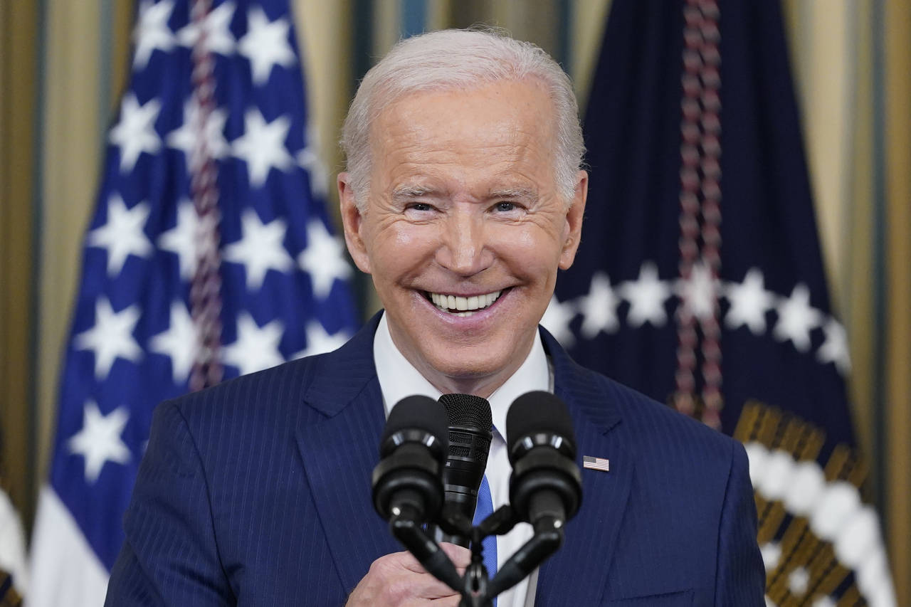 FILE - President Joe Biden smiles as he speaks in the State Dining Room of the White House in Washi...