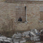 
              Vadym Zherdetsky is seen in a w  indow of his house destroyed by fighting, in the village of Moshun, outside Kyiv, Ukraine, Friday, Nov. 4, 2022. When Russia invaded Ukraine in February, two missiles struck Zherdetsky's home in the tiny village of Moschun on the outskirts of the capital, Kyiv, ripping the roof off and nearly killing four of his family members. (AP Photo/Andrew Kravchenko)
            