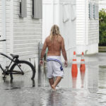 
              A resident walks through flooding caused by the rain bands of Hurricane Nicole in Briny Breezes, Fla., on Wednesday, Nov. 9, 2022. (Joe Cavaretta/South Florida Sun-Sentinel via AP)
            