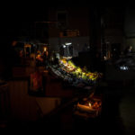 
              Camping lights and candles illuminate a market fruit stall during a power outage in central Kyiv, Ukraine, Wednesday, Nov. 9, 2022. (AP Photo/Bernat Armangue)
            