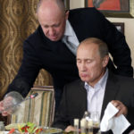 
              FILE - Yevgeny Prigozhin, top, serves food to then-Russian Prime Minister Vladimir Putin at Prigozhin's restaurant outside Moscow, Russia in Nov. 11, 2011. Kremlin-connected businessman Yevgeny Prigozhin kept a low profile over the years, but he has been increasingly in the spotlight recently. He has admitted that he is behind the Russian mercenary force that reportedly has been involved in conflicts around the world, including Ukraine. (AP Photo/Misha Japaridze, Pool, File)
            