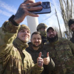 
              In this photo provided by the Ukrainian Presidential Press Office and posted on Facebook, Ukrainian soldiers take a selfie with President Volodymyr Zelenskyy, centre, during his visit to Kherson, Ukraine, Monday, Nov. 14, 2022. Ukraine's retaking of Kherson was a significant setback for the Kremlin and it came some six weeks after Russian President Vladimir Putin annexed the Kherson region and three other provinces in southern and eastern Ukraine — in breach of international law — and declared them Russian territory. (Ukrainian Presidential Press Office via AP)
            