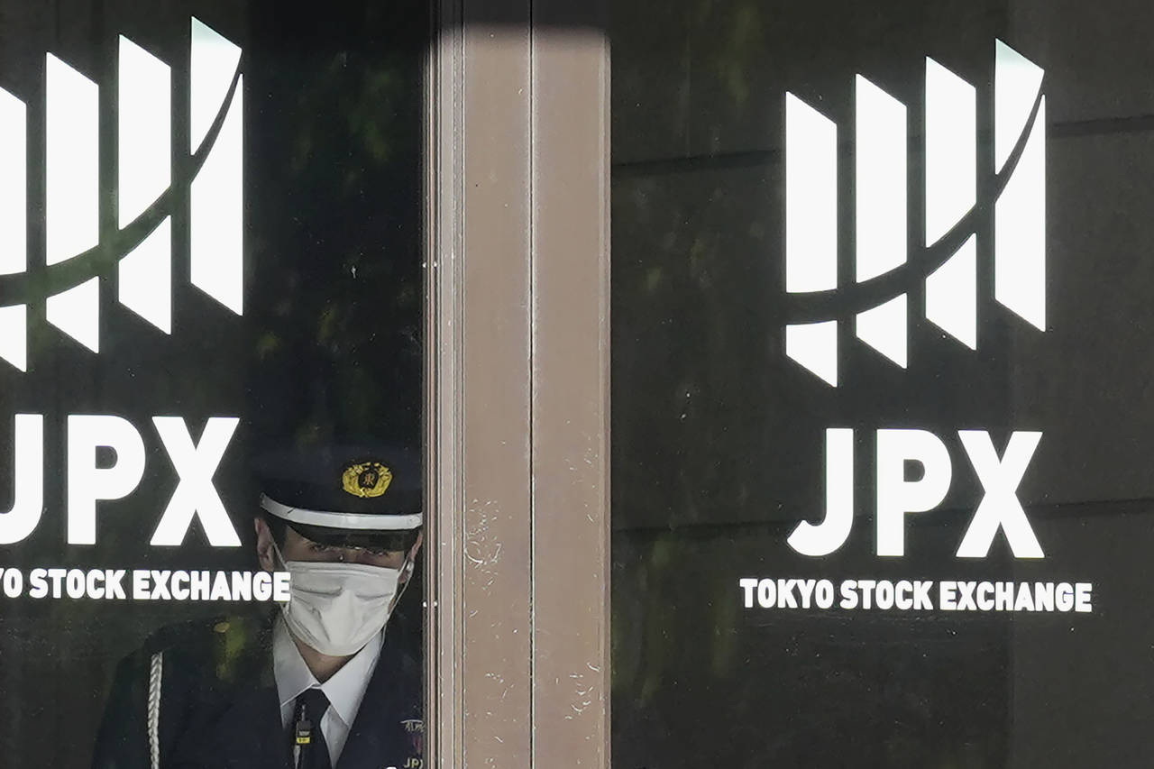 A security guard stands guard at the entrance of the Tokyo Stock Exchange building Wednesday, Nov. ...
