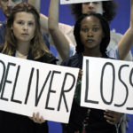 
              Climate activists, from left, Luisa Neubauer, of Germany, and Patience Nabukalu, of Uganda, hold signs with other youth activists encouraging world leaders to maintain policies that limit warming to 1.5 degrees Celsius since pre-industrial times and provide reparations for loss and damage at the COP27 U.N. Climate Summit, Saturday, Nov. 19, 2022, in Sharm el-Sheikh, Egypt. (AP Photo/Nariman El-Mofty)
            