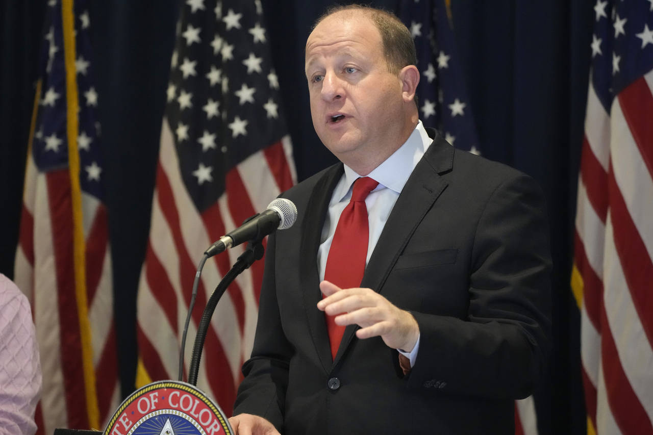 FILE - Colorado Gov. Jared Polis makes a point during a news conference after unveiling his balance...