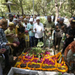 
              People pray near the grave of a victim of a cable bridge that collapsed on Sunday in Morbi town of western state Gujarat, India, Wednesday, Nov. 2, 2022. A century-old cable suspension bridge collapsed into the river Machchhu on Sunday evening, sending hundreds plunging in the water in one of the country's worst accidents in years. (AP Photo/Ajit Solanki)
            