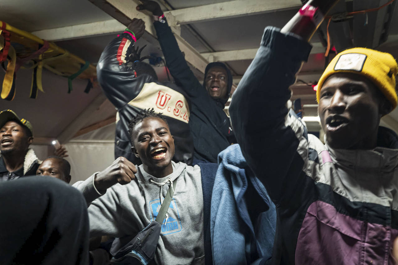 Migrants celebrate on the deck of the Rise Above rescue ship run by the German organization Mission...