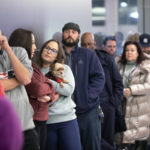 
              Kylie Haigh holds her dog Rob, a 10-year-old Chihuahua-Yorkie mix, as she waits in line to vote at the Galleria at Sunset shopping mall in Henderson, Nev., Tuesday, Nov. 8, 2022. (Steve Marcus/Las Vegas Sun via AP)
            