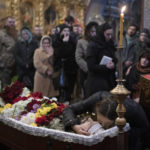
              Relatives, friends, and comrades mourn next to the coffin of Ukrainian serviceman Sergii Myronov, killed fighting Russian troops in Donetsk region, during a funeral ceremony at St. Michael's Golden-Domed Monastery in Kyiv, Ukraine, Wednesday, Nov. 23, 2022. (AP Photo/Andrew Kravchenko)
            