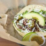 The Crossroads taco draws inspiration from Texas, featuring smoked beef brisket, avocado, jack cheese, jalapeños and grilled onions. (Facebook Photo/Torchy's Tacos - Queen Creek)