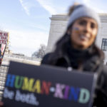 
              A person dressed as a bible holds a sign that reads "Use Me Not For Your Bigotry" as pro-gay rights supporter Amrita Bhowmick, foreground, stands outside the Supreme Court in Washington, Monday, Dec. 5, 2022. The Supreme Court is hearing the case of a Christian graphic artist who objects to designing wedding websites for gay couples, that's the latest clash of religion and gay rights to land at the highest court. (AP Photo/Andrew Harnik)
            