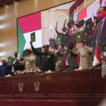 
              Sudan's Army chief Gen. Abdel-Fattah Burhan, center, and others hold a document following the signature of an initial deal aimed at ending a deep crisis caused by last year's military coup, in Khartoum, Sudan, Monday, Dec. 5, 2022. Sudan’s coup leaders and the main pro-democracy group signed a deal to establish a civilian-led transitional government following the military takeover last year. But key players refused to participate, and no deadline was set for the transition to begin. (AP Photo/Marwan)
            