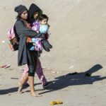 
              A migrant mother carries her child while walking toward the border fence after crossing the Rio Grande in their attempt to enter into El Paso, Texas from Ciudad Juarez, Mexico, Wednesday, Dec. 21, 2022. Thousands of migrants gathered along the Mexican side of the southern border Wednesday, camping outside or packing into shelters as they waited for the U.S. Supreme Court to decide whether and when to lift pandemic-era restrictions that have prevented many from seeking asylum. (AP Photo/Andres Leighton)
            