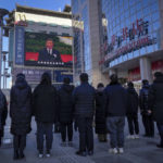 
              People watch a live broadcast of the memorial service for late former Chinese President Jiang Zemin where Chinese President Xi Jinping makes a speech on screen at the Wangfujing shopping street in Beijing, Tuesday, Dec. 6, 2022. A formal memorial service was held Tuesday at the Great Hall of the People, the seat of the ceremonial legislature in the center of Beijing. (AP Photo/Andy Wong)
            