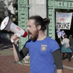 
              Tyler Manning, a post-doctoral researcher at UC Berkeley, leads a chant as striking academic workers picket on the University of California, Berkeley campus in Berkeley, Calif., Wednesday, Dec. 7, 2022. A month into the nation's largest strike involving higher education, classes are being cancelled and important research is being disrupted at the 10 campuses of the University of California. (AP Photo/Terry Chea)
            