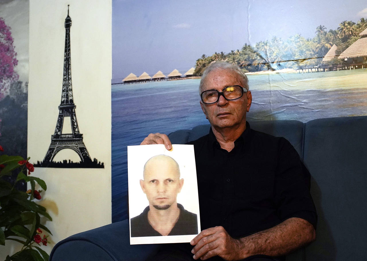 FILE - Nelson Faria Marinho shows a picture of his son Nelson Marinho, who lost his life in the 200...