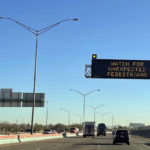 
              An electronic sign flashes "Watch for unexpected pedestrians," Tuesday, Dec. 20, 2022, on the highway next to the fenced US-Mexican border just east of downtown El Paso, Texas, next to one of the three bridges that connect the Texas city with the sprawling metropolis of Juarez, Mexico. Many migrant advocates expect Juarez to "empty out" if Title 42 is lifted, since thousands of migrants have been biding their time there, waiting for a chance to cross into the United States without being immediately sent back. (AP Photo/Giovanna Dell'Orto)
            