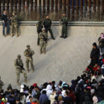 
              Migrants congregate on the banks of the Rio Grande at the U.S. border with Mexico on Tuesday, Dec. 20, 2022, where members of the Texas National Guard cordoned off a gap in the U.S. border wall. Restrictions that prevented many from seeking asylum in the U.S. remained in place beyond their anticipated end. (AP Photo/Morgan Lee)
            
