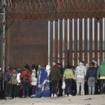 
              A U.S. Border Patrol stands before a line of migrants before letting the group enter into El Paso, Texas, from Ciudad Juarez, Mexico, Wednesday, Dec. 21, 2022. Migrants gathered along the Mexican side of the southern border Wednesday as they waited for the U.S. Supreme Court to decide whether and when to lift pandemic-era restrictions that have prevented many from seeking asylum. (AP Photo/Christian Chavez)
            