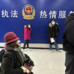 
              Residents line up at the community police station for document applications including for passports near the words "Strict law enforcement, enthusiastic service" in Beijing, Wednesday, Dec. 28, 2022. China says it will resume issuing passports for tourism in another big step away from anti-virus controls that isolated the country for almost three years, setting up a potential flood of Chinese going abroad for next month's Lunar New Year holiday. (AP Photo/Ng Han Guan)
            