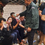 
              In this photo provided by Cambodia's Fresh News, victims of a fire receive water from police officers  near a Cambodia-Thai international border gate in Poipet, west of Phnom Penh, Cambodia, Wednesday, Dec. 28, 2022. A fire burning through the Grand Diamond City Casino and Hotel has killed multiple people and injured dozens of others, police said Thursday, and neighboring Thailand sent firetrucks to help fight the blaze in a bustling border region. (Fresh News via AP)
            