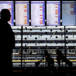 
              Travelers walk past flight information screens displaying flight status information at O'Hare International Airport in Chicago, Thursday, Dec. 22, 2022. (AP Photo/Nam Y. Huh)
            