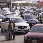 
              Cars line up to pick up travelers at Love Field Airport in Dallas, Wednesday, Dec. 21, 2022. (AP Photo/LM Otero)
            