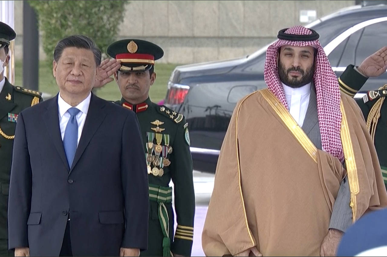 In this image taken from footage by Saudi State TV, Chinese President Xi Jinping, left, listens to ...